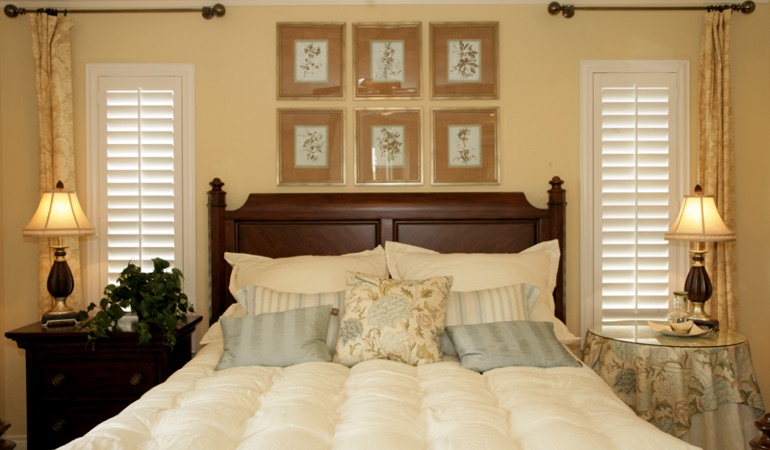 Bedroom with two tall plantation shutters on either side of bed in Chicago 